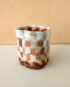 A small square tea cup with a contrasting nerikomi checker pattern.