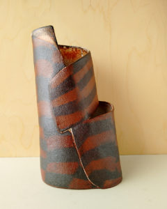 A tall, slanted vase with two openings in a nerikomi checker pattern.