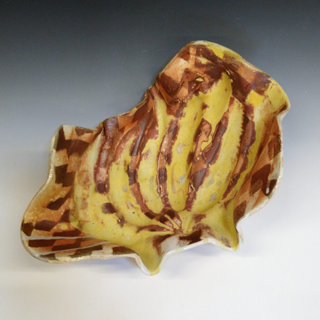 Banana Bowl 03 is a soda-fired ceramic fruit bowl with a sunshine yellow glaze over a warm brown nerikomi checker pattern.