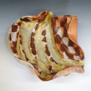 Banana Bowl 04 is a soda-fired ceramic fruit bowl with a sunshine yellow glaze over a warm brown nerikomi checker pattern.