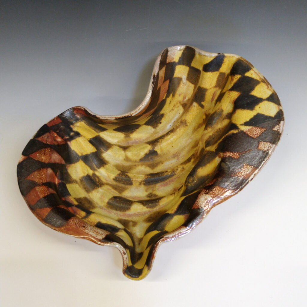 Banana Bowl 08 is a soda-fired ceramic fruit bowl with a sunshine yellow glaze over a warm brown nerikomi checker pattern.