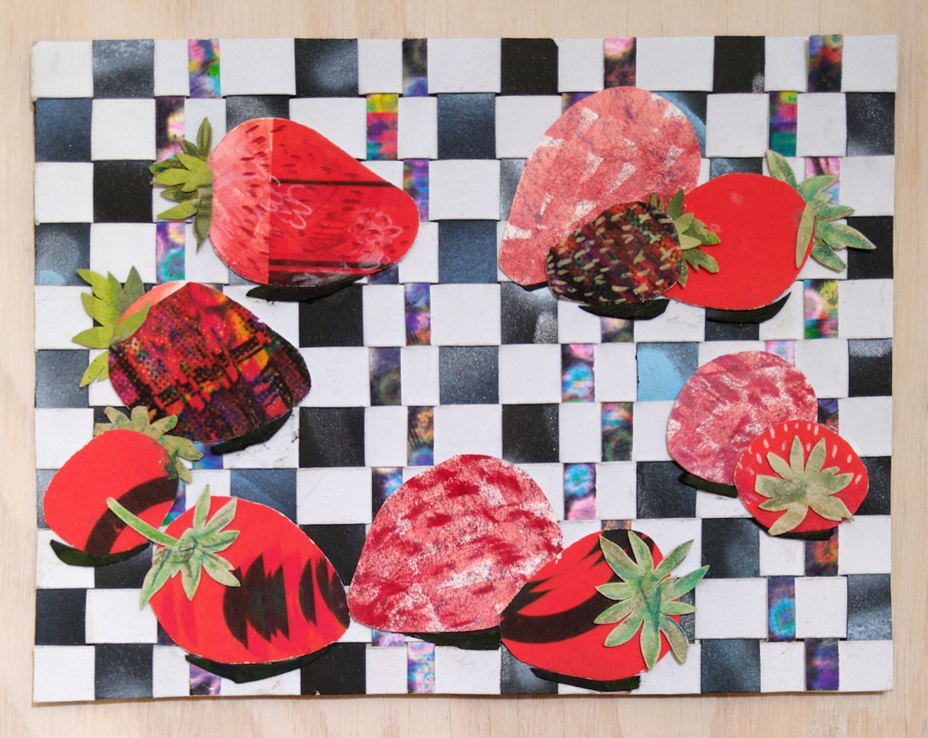 Cosmic Strawberries 3 is a small collage drawing showing eleven strawberries on a woven checker background by Isa Rodriguez.