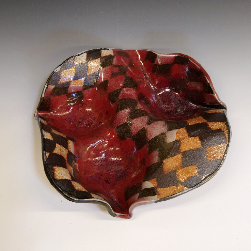 Orange Bowl 01 is a soda-fired ceramic fruit bowl with a blood-red glaze over a dark brown nerikomi checker pattern.