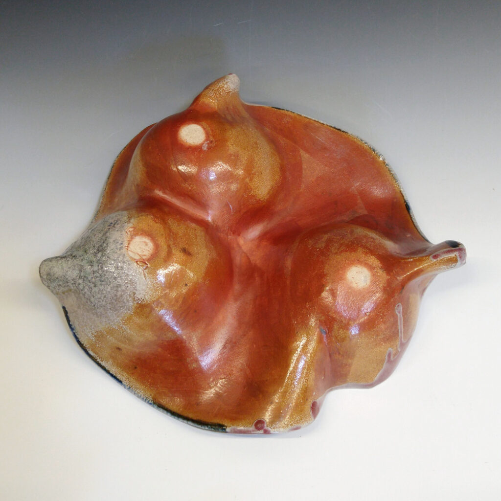 Orange Bowl 01 is a soda-fired ceramic fruit bowl with a blood-red glaze over a dark brown nerikomi checker pattern.